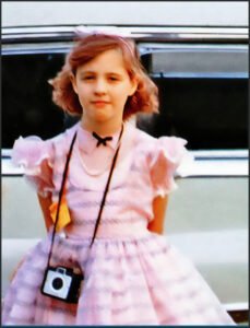 Young Penelope in pink dress with a Browny Camera